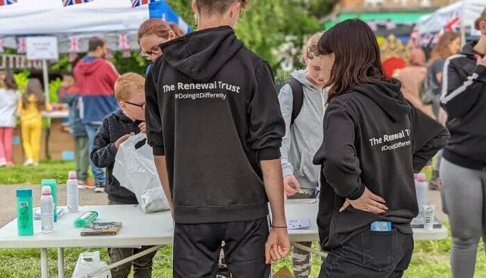 Two people with Renewal Trust jumpers on at an event
