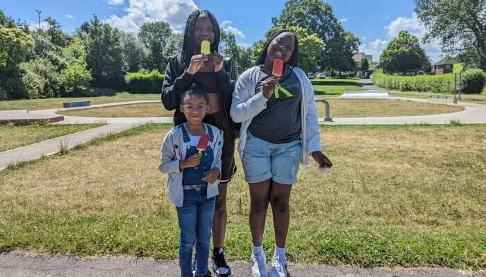 Three children smiling and holding ice creams
