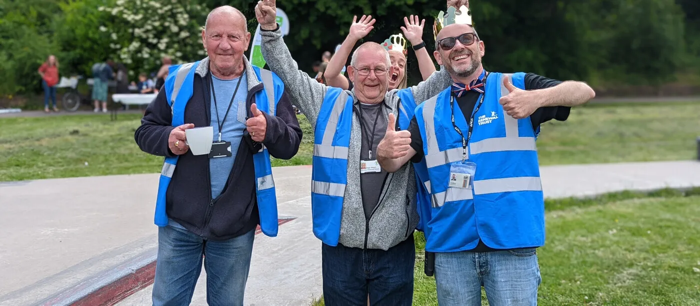Three people stood together smiling 
